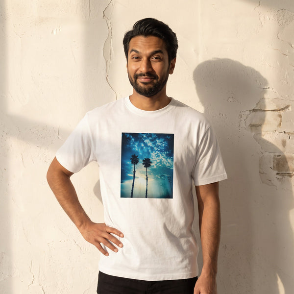 Gratitude - "Bubbles and Sky Sticks" White T-shirt worn against a sunlit plaster wall