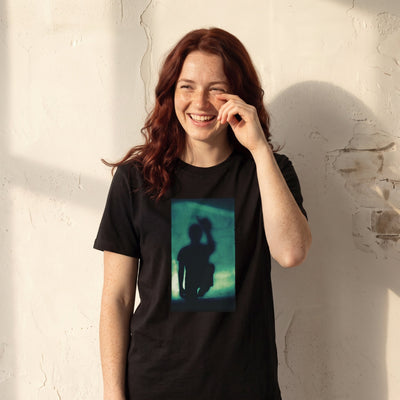 Joy - "Dancing Cowboy" Deep Black T-shirt worn against a sunlit plaster wall