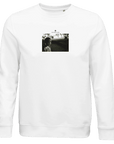 A white crewneck sweatshirt features a centered black-and-white art print of a person looking at the camera, with "INTERIORITY" printed above—perfect for those who appreciate mindful apparel and conscious fashion.