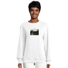 A person wearing a white sweatshirt featuring a small black and white art print on the chest. The photo shows people walking on a street, highlighting this piece of mindful apparel against a plain, light-colored background.